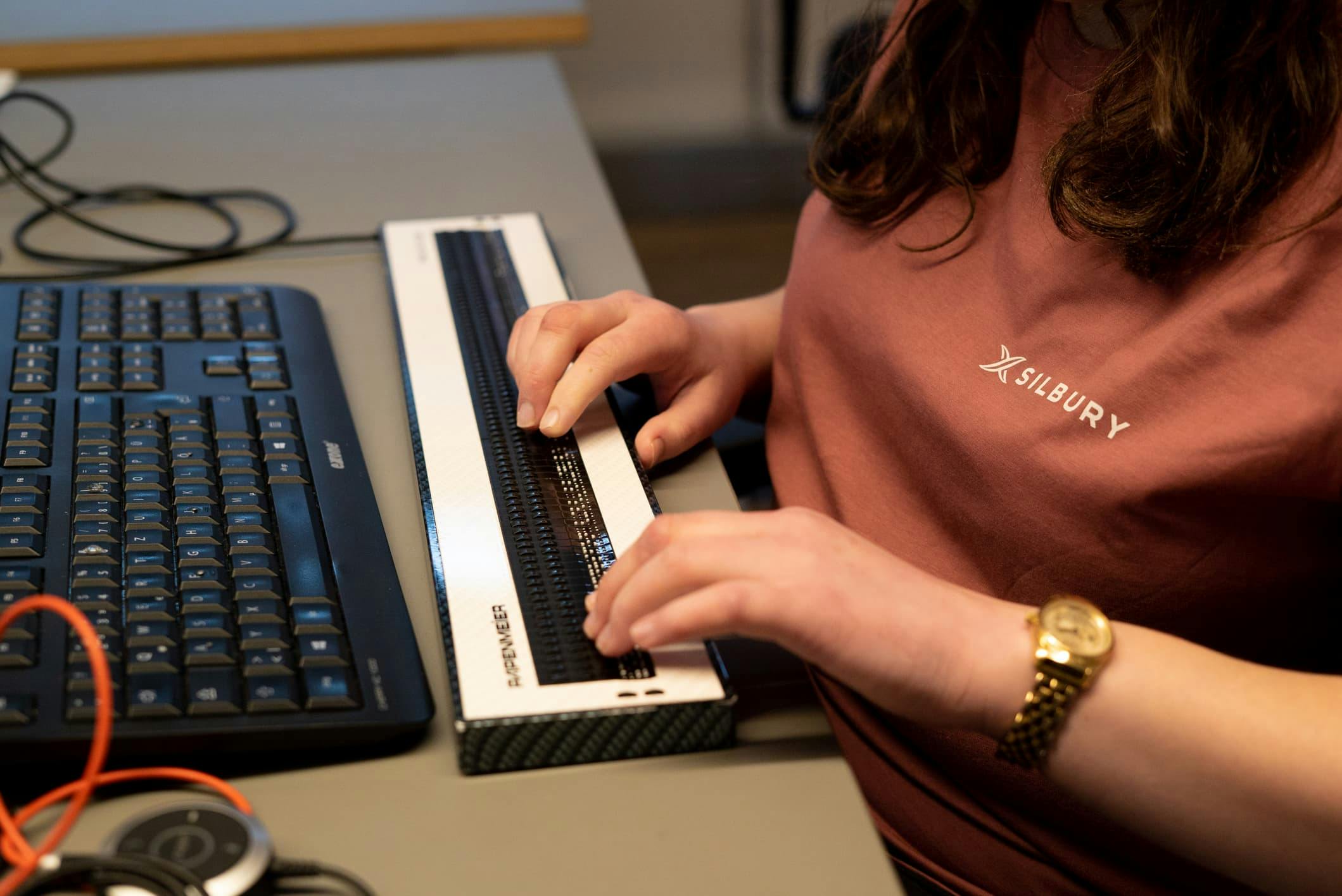 Melanie mit ihren Händen auf der Braillezeile